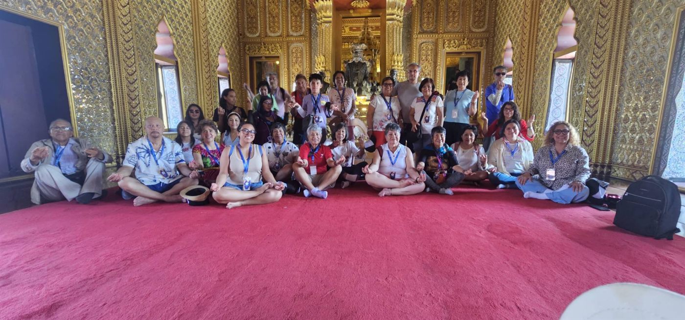 Large inbound group inside a Thai temple hall